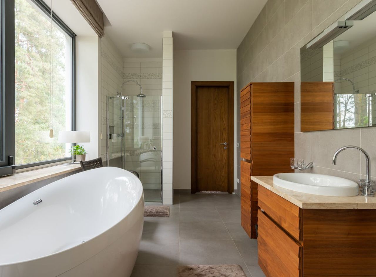 Modern luxury bathroom with tile shower, freestanding tub and floating wood vanity.