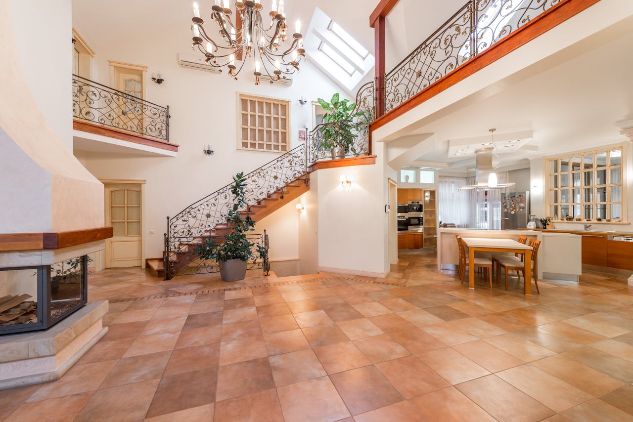Grand entryway with tile flooring and ornate staircase railing.